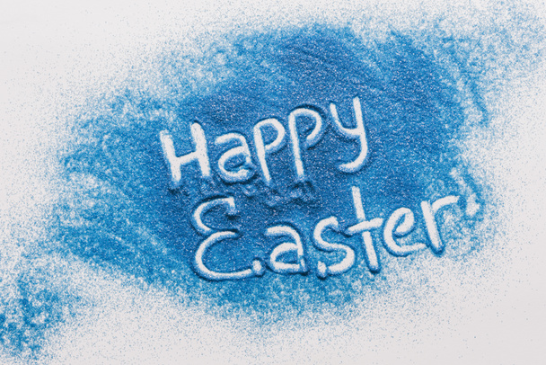 felülnézet Boldog húsvéti jel készült kék homok, fehér felületre - Fotó, kép