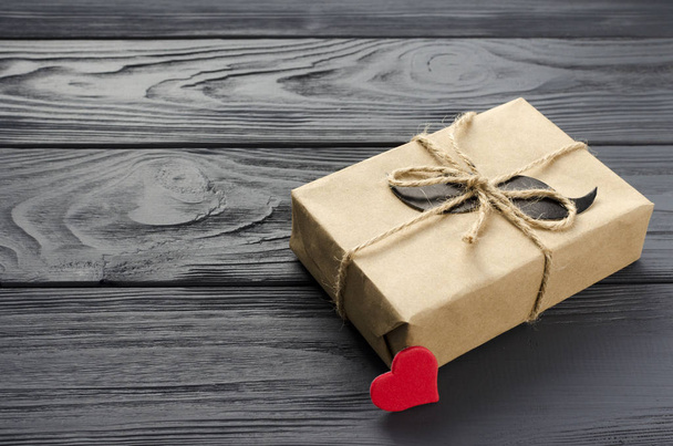 подарункова коробка, загорнута в крафт-папір з паперовими вусами і червоним слухом
 - Фото, зображення