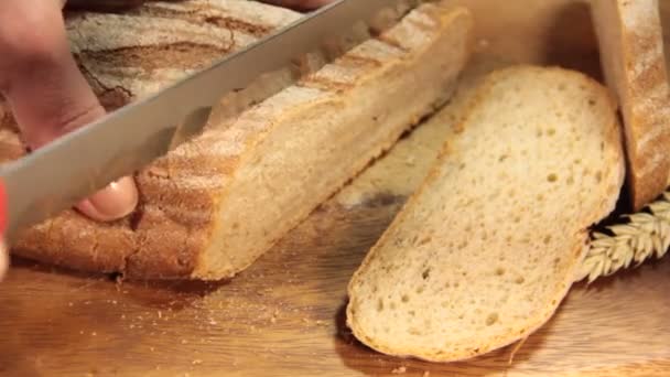 la mano corta el pan en una madera
 - Metraje, vídeo