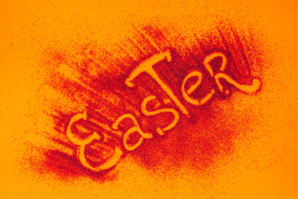 top view of easter sign made of red sand on orange surface - Foto, Imagem