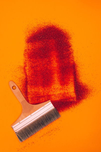 top view of red sand for decoration and brush isolated on orange - Valokuva, kuva
