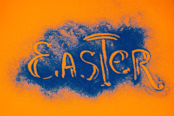 オレンジ色の表面にブルーの砂で作られたイースター記号のトップ ビュー - 写真・画像