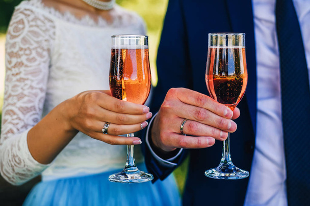 mains de mariée et marié avec verres à champagne avec anneaux
 - Photo, image