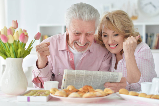 Close-up portrait of a  senior couple with newspaper  at home  - Photo, image