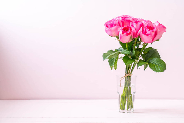 pink rose in vase on wood background - Foto, Imagem