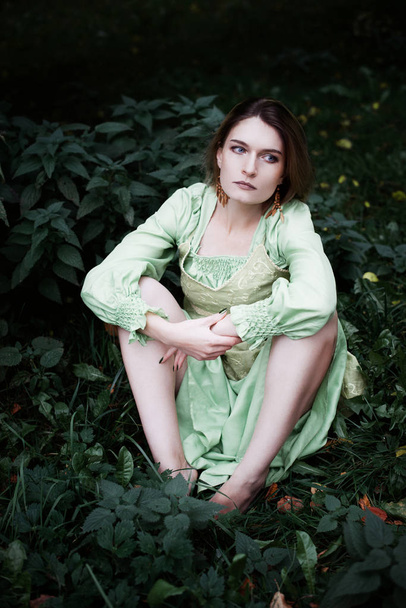 mavka. eine schöne Frau in einem grünen Kleid geht durch den Wald. - Foto, Bild