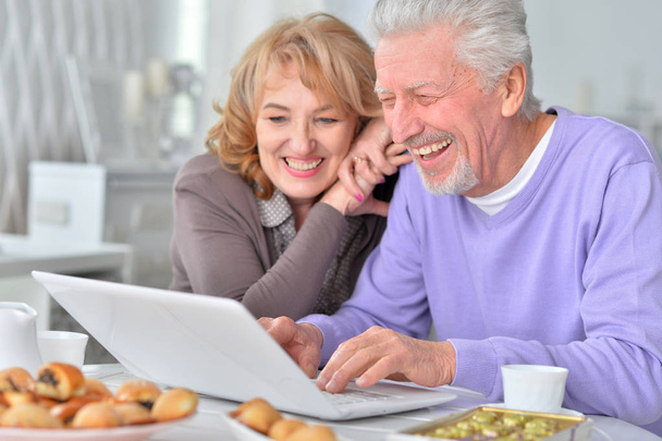 ευτυχισμένο ζευγάρι ηλικιωμένων με φορητό υπολογιστή στο σπίτι - Φωτογραφία, εικόνα