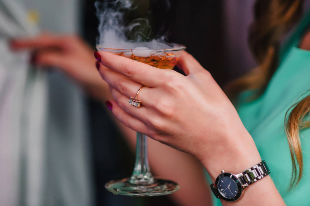 womans hand with a Martini glass with bubbles and steam - 写真・画像
