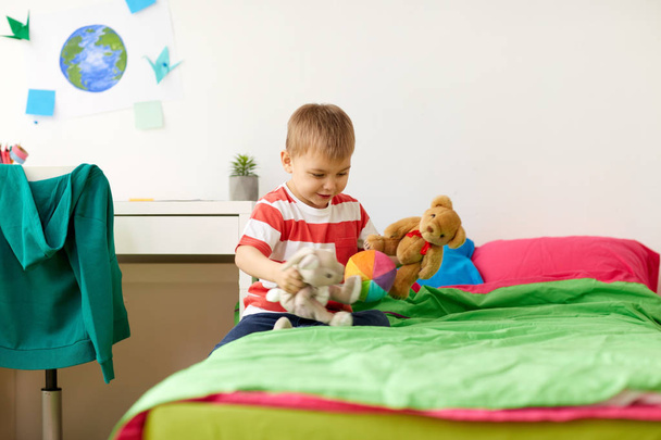 boldog kisfiú játszik otthon a plüss játékok - Fotó, kép