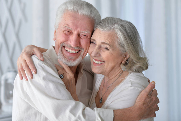 portrait of a happy senior couple hugging  at home - 写真・画像
