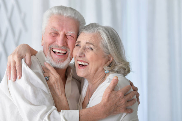 portrait of a happy senior couple hugging  at home - 写真・画像