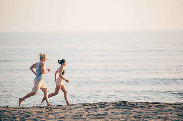 Man and Woman Running by the Sea - Фото, зображення