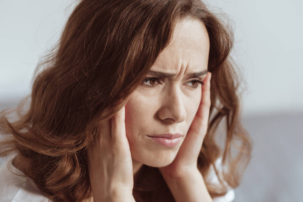 Close up portrait of woman struggling with headache - Foto, afbeelding