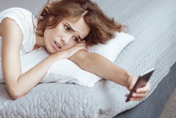 Irritated mature lady getting depressed while looking at phone - Фото, зображення