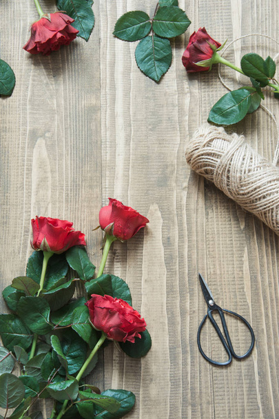 Working table florist. Preparation a bouquet of red roses. - Φωτογραφία, εικόνα