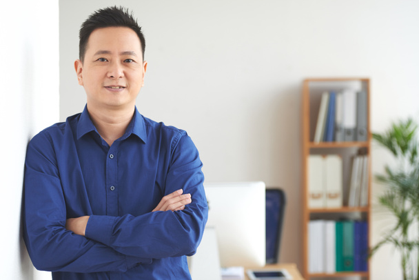 Πορτρέτο του αυτοπεποίθηση Ασίας επιχειρηματίας που στέκεται με τα χέρια σταυρωμένα - Φωτογραφία, εικόνα