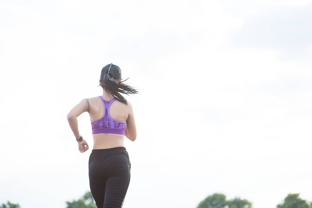 Jonge vrouw runner is joggen op de straat worden uitgevoerd voor exerc - Foto, afbeelding