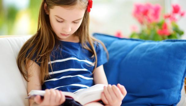 girl reading book in living room - Foto, Imagen