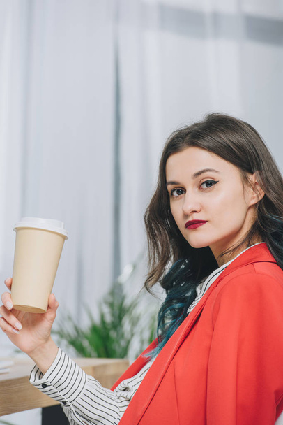 Pretty lady holding coffee cup in light office - Photo, image