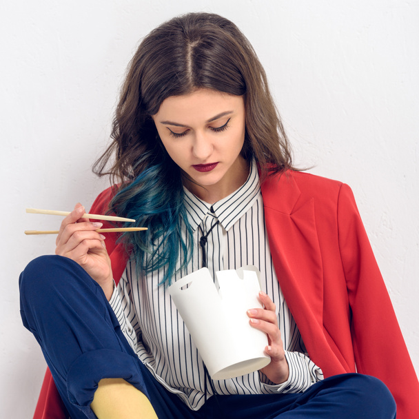 Mujer elegante joven mirando cartón con comida china
 - Foto, Imagen