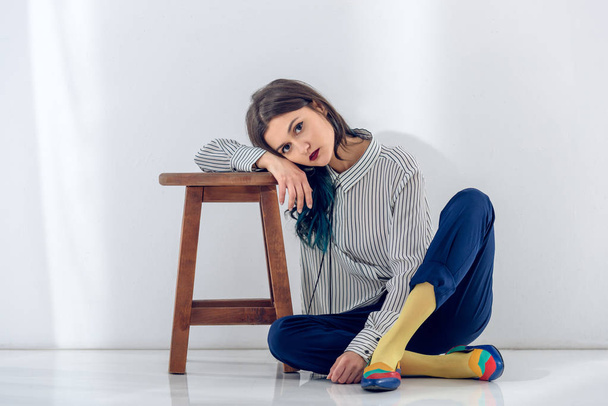 Young woman sitting on floor by the wooden chair - Photo, image
