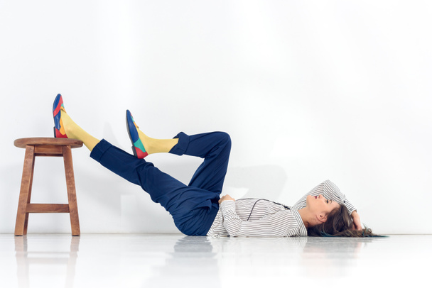 Houkutteleva nuori tyttö lepää lattialla valkoisella taustalla
 - Valokuva, kuva