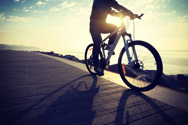 cyclist riding bike in the sunrise coast path - Zdjęcie, obraz