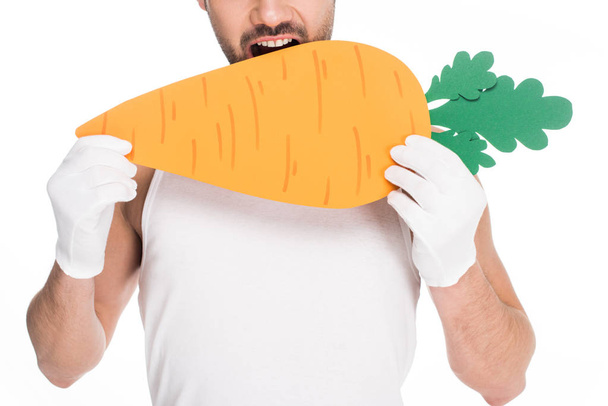 Closeup view of man bitting big carrot isolated on white, easter concept - Photo, Image