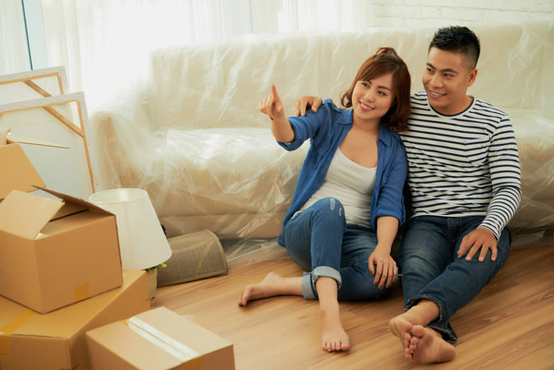 Sorrindo casal asiático discutindo como eles vão projetar novo apartamento
 - Foto, Imagem