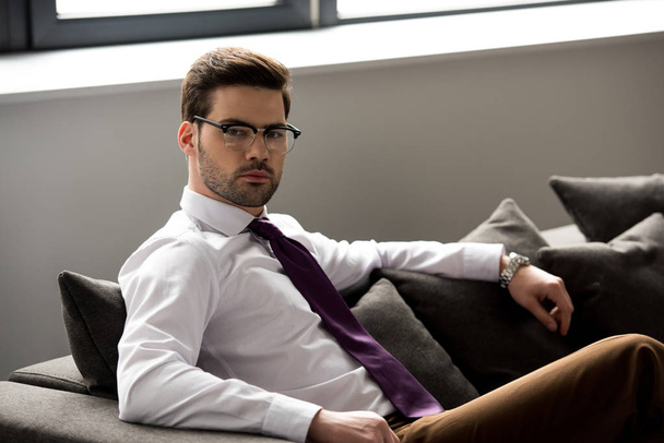 Portrait of stylish businessman in glasses looking at camera - Foto, afbeelding