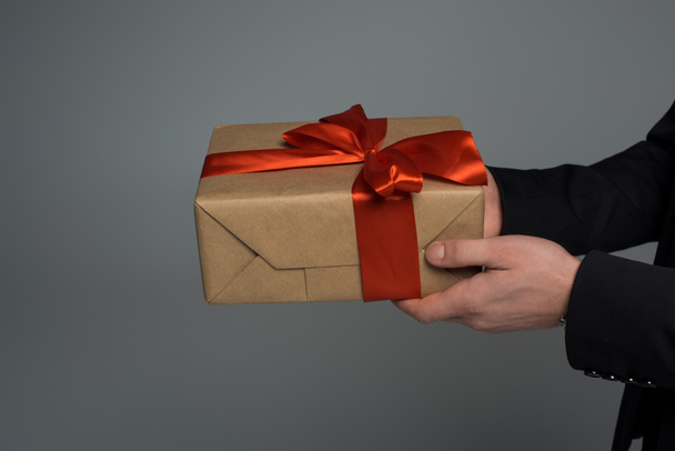 Closeup view of gift box in male hands isolated on grey, international womens day concept - Fotografie, Obrázek