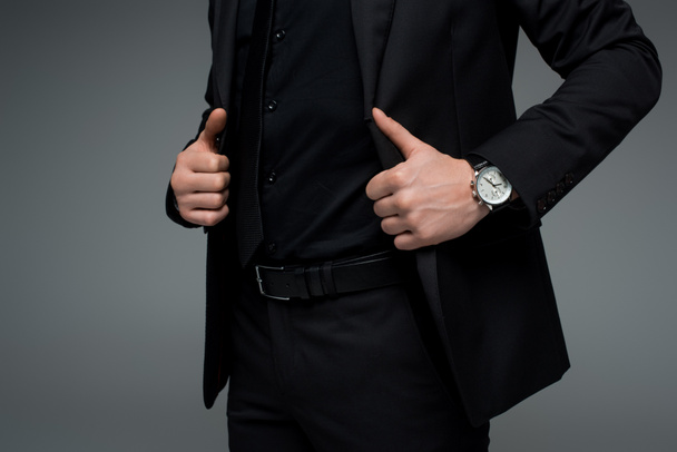 Teilansicht männlicher Hände mit Jacke isoliert auf grau - Foto, Bild