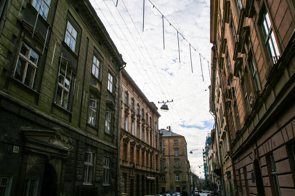 sylwetki odwieczne domów w cieniu ulicy z lamp ulicznych i oświetlenie przeciw błękitne niebo chmury w stare miasto europejskie - Zdjęcie, obraz