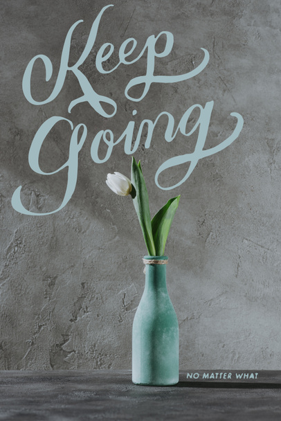 fehér tavaszi tulipán kék vázában, folytasd felirat szürke felületen - Fotó, kép