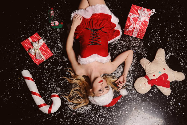 クリスマスプレゼントとサンタクロースの服を着てセクシーな女性 - 写真・画像