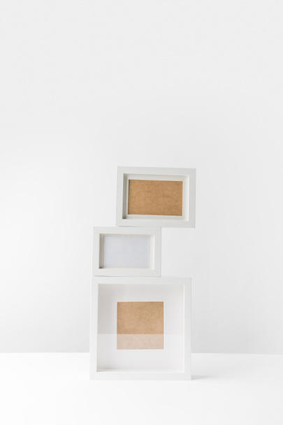 empty white photo frames stacked on white - Фото, изображение