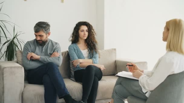 Married couple listening professional psychologist and trying to solve relationship porblems during visit psychotherapist office - Filmmaterial, Video