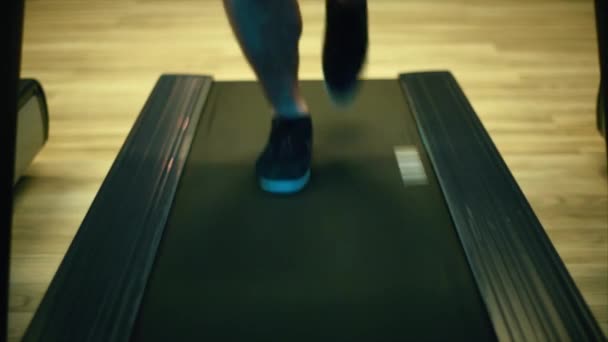Male legs in sneakers run on an orbitrek-simulator. Close up - Felvétel, videó