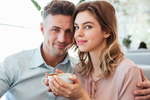 Portrait of a smiling young couple drinking coffee - Foto, Imagem
