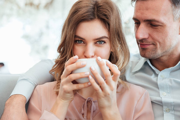 Portrait of a cheerful young couple drinking coffee - Foto, Bild