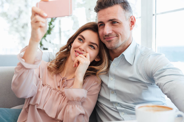 Portrait of a happy young couple taking a selfie - Photo, image