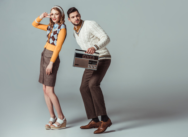 beautiful retro styled couple dancing with vintage radio on grey - Foto, Imagen