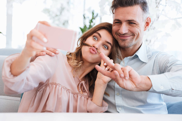 Photo of young and beautiful couple making selfie and fooling ar - Photo, image