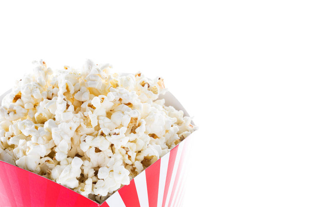 De popcorn in de verpakking gestreepte geïsoleerd op een witte achtergrond. Copyspace - Foto, afbeelding