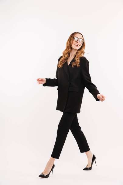Full-length businesswoman with brown curls wearing black clothes - Photo, image