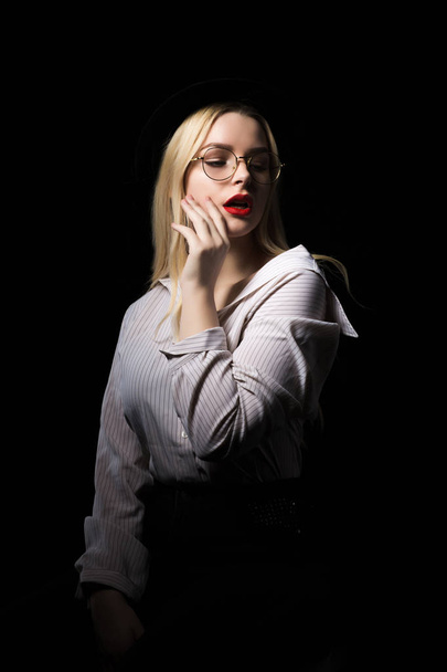 Séduisante femme blonde dans des lunettes posant avec studio dramatique li
 - Photo, image