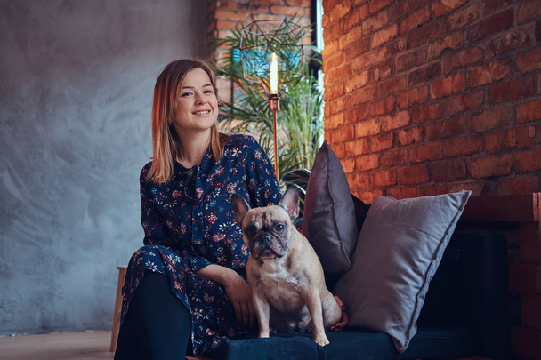 Portrait of a smiling attractive woman sitting with a cute pug - Photo, Image