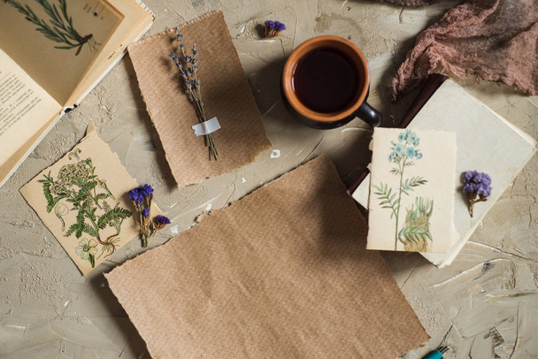Flay lay, top view of the herbarium, dried lavender flowers, notebook, book for notes, pen and spring summer pictures on a concrete background. Postcard on paper - Fotó, kép