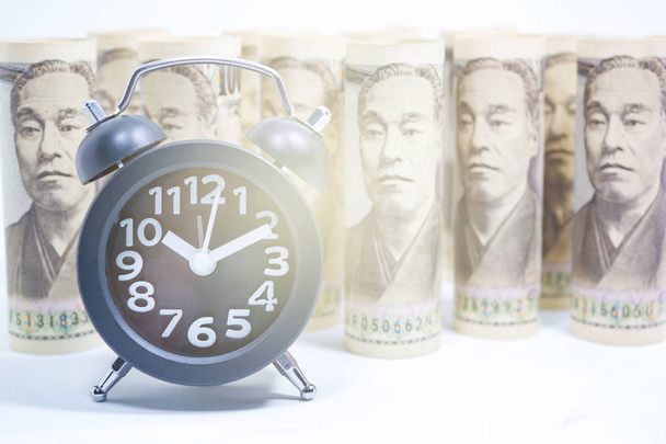 古典的な時計のロールの円紙幣、アジアにおけるコンセプトとアイデアの時間値、お金、ビジネスとファイナンスの概念、金融市場 - 写真・画像