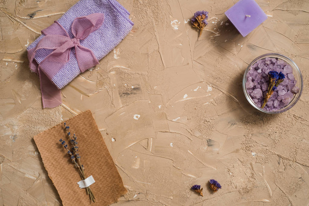 Purple sea salt, a wooden comb towel on a concrete brown background. - Photo, image